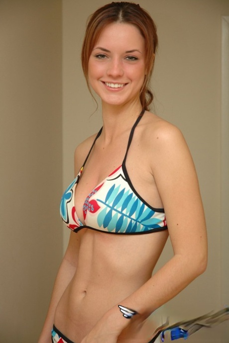 Young solo girl Amy wears a smile while posing non nude in a string bikini