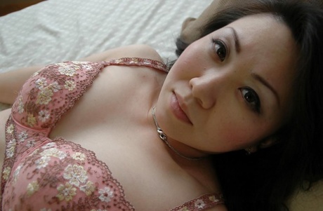 Asian MILF gets rid of her lingerie and exposes her hairy cunt