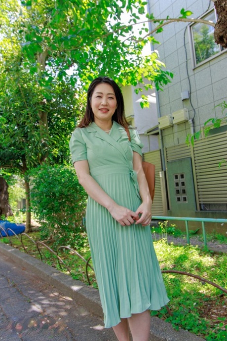 Japanese MILF Megumi Satuki shows her body and poses on a couch