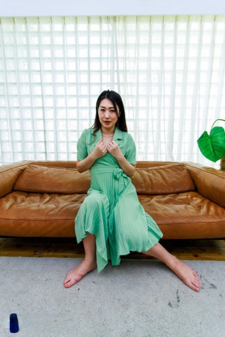 Japanese MILF Megumi Satuki shows her body and poses on a couch