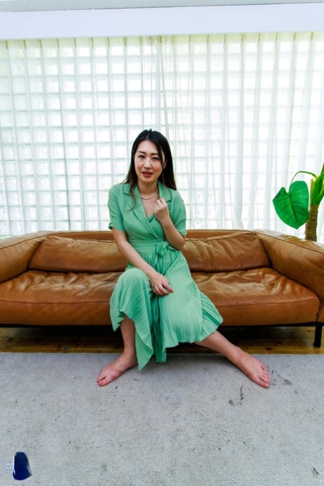 Japanese MILF Megumi Satuki shows her body and poses on a couch